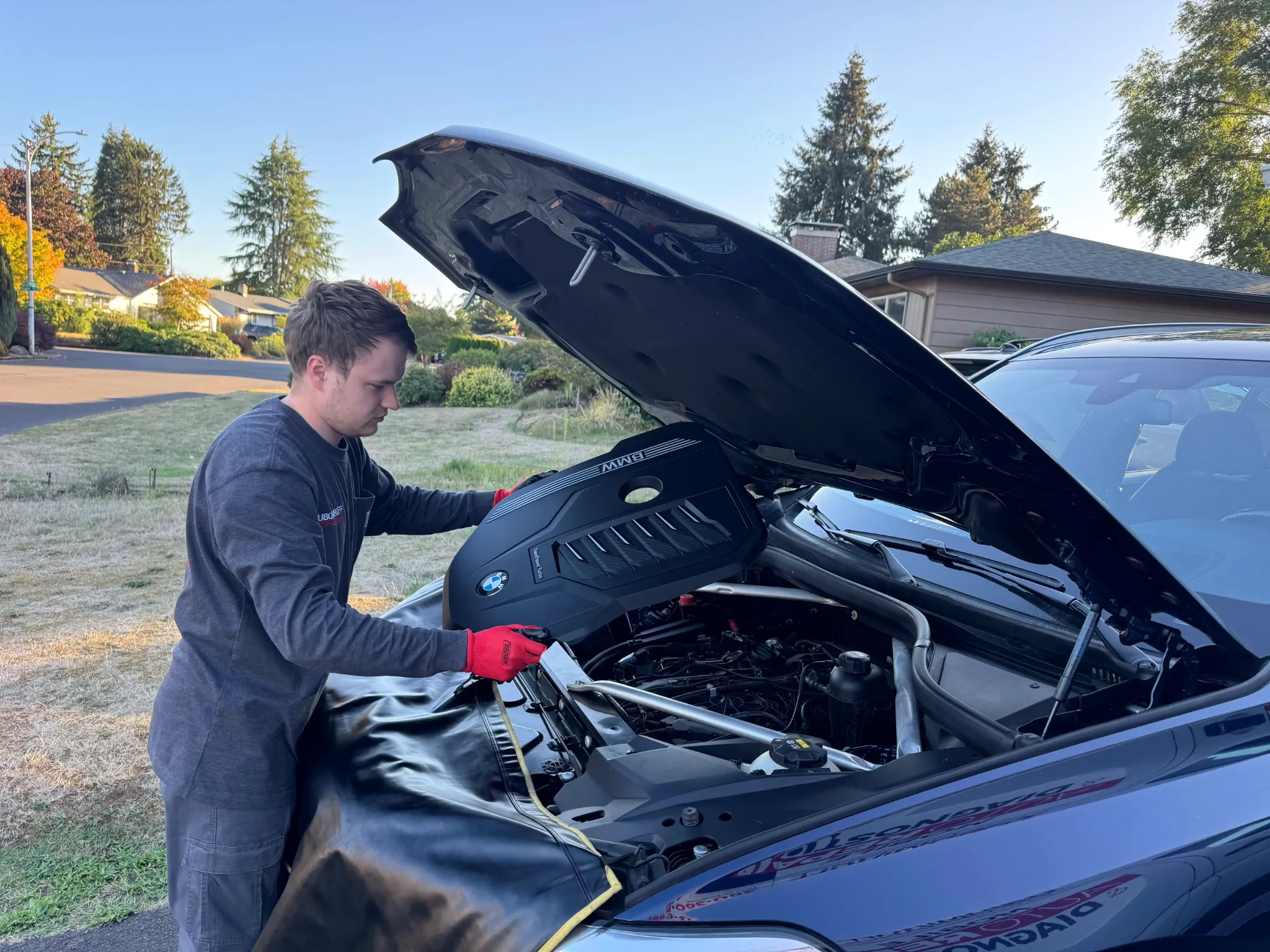 Alex working under the hood of a BMW