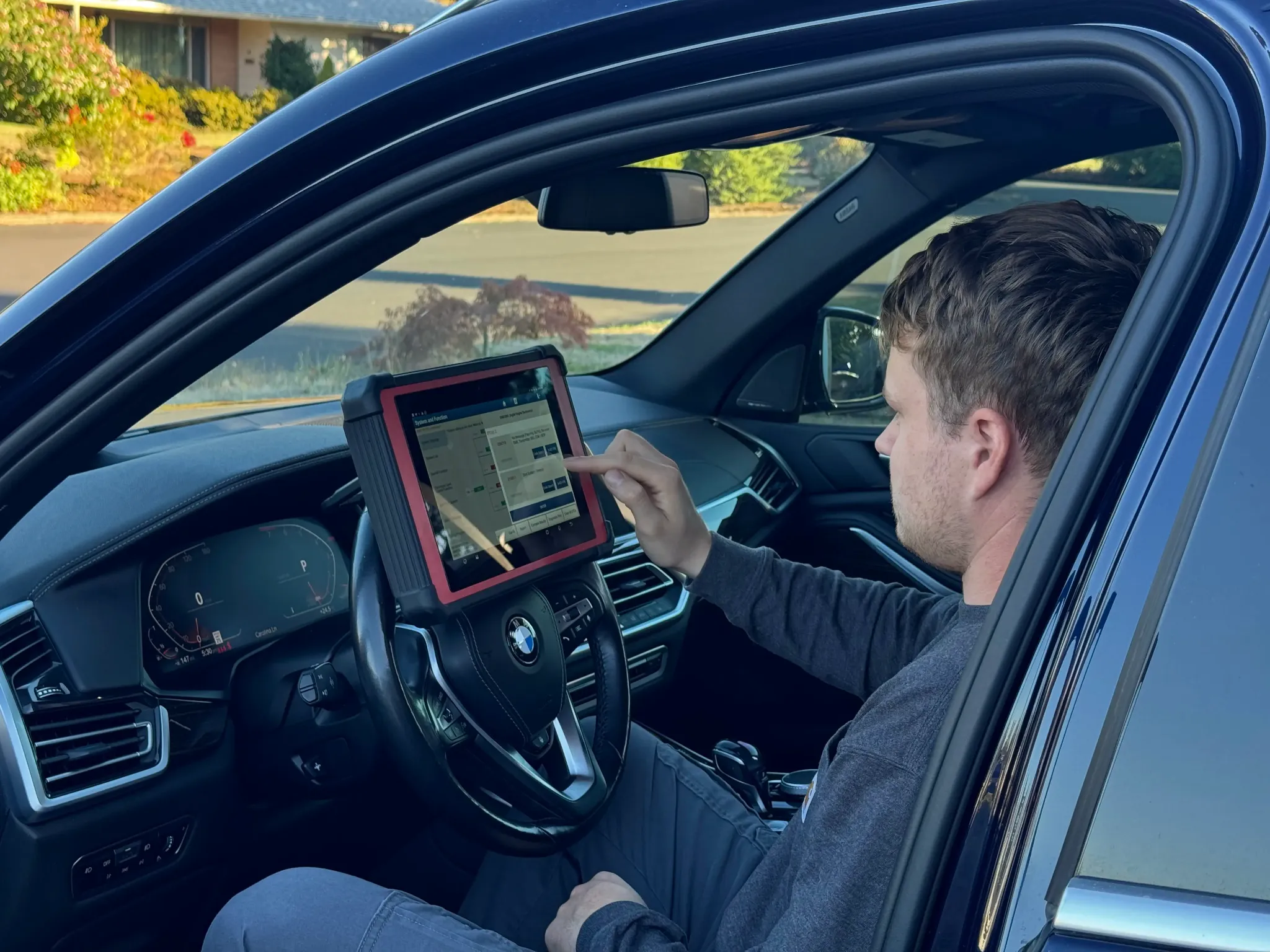 Alex using a diagnostic scan tool inside a vehicle