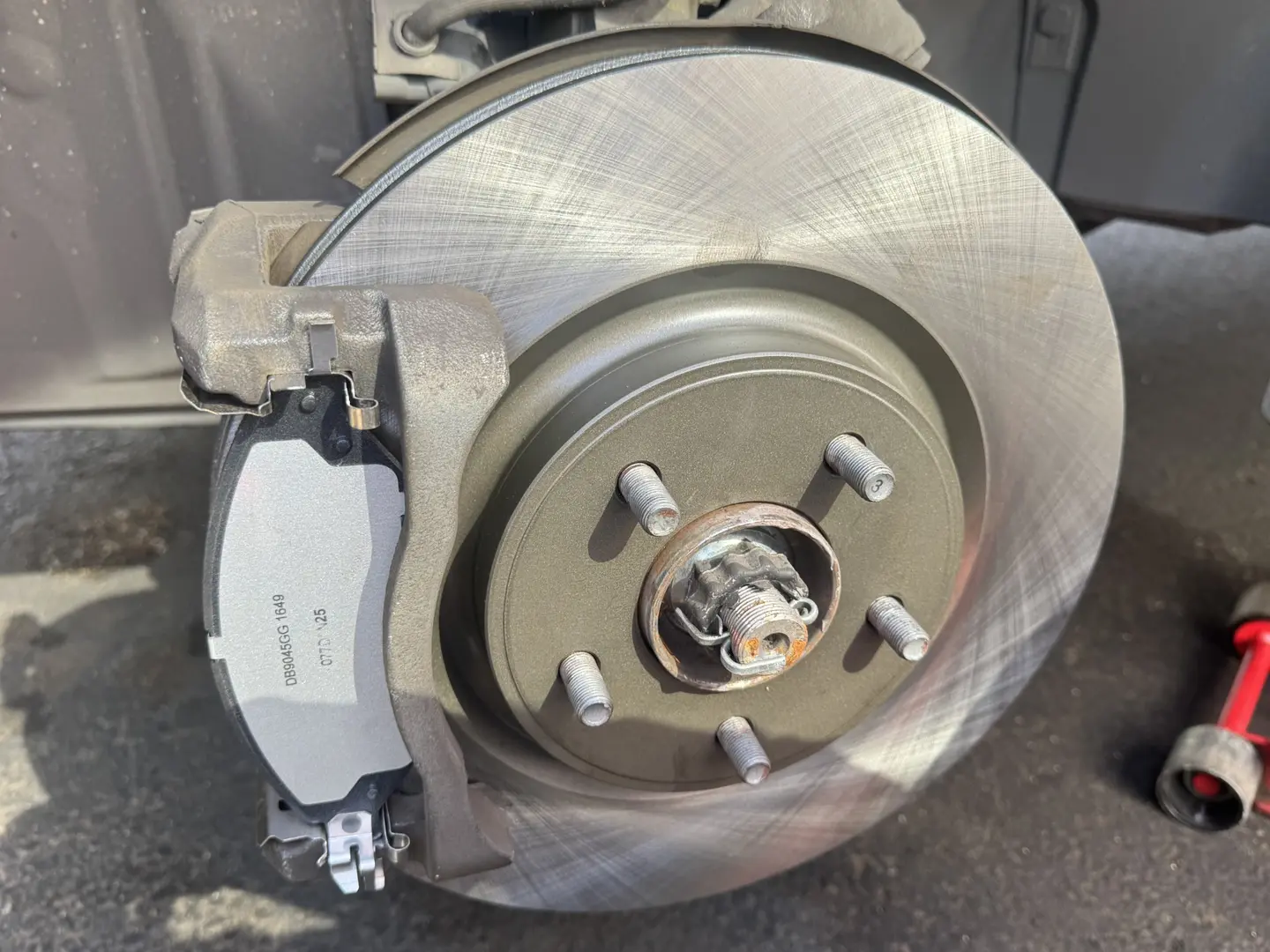New front brake rotor and brake pads installed on a 2014 Nissan Pathfinder.