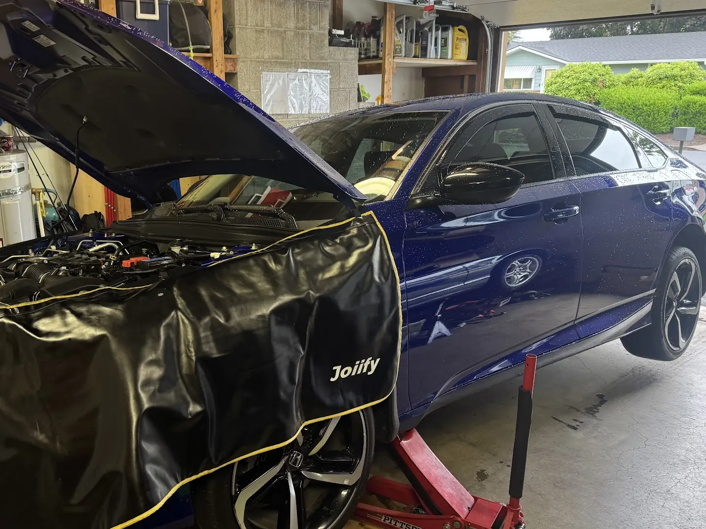 Blue 2022 Honda Accord raised in a garage during ABS and traction-control diagnosis.